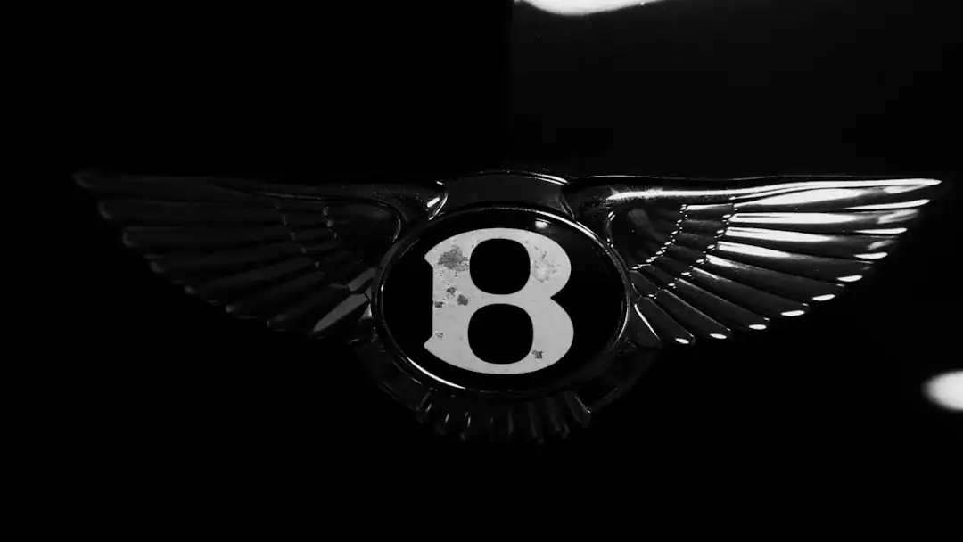 Illustration of Macro photography close-up of two metallic luxury car emblems side-by-side. On the left, a polished.