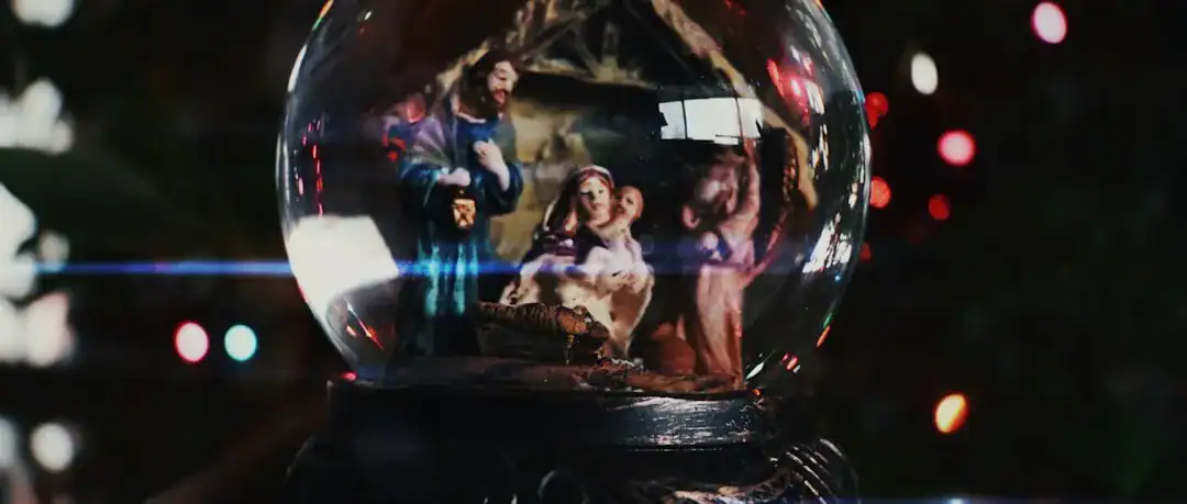 Glass sphere with a miniature luxury scene featuring a suited figure and a car, against city lights