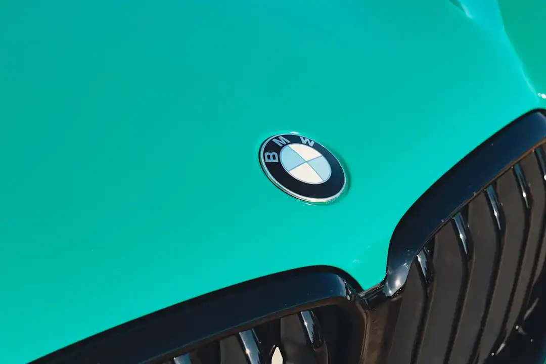 Illustration of Macro photography of a BMW roundel emblem on a metallic car hood, focusing on the blue and white.