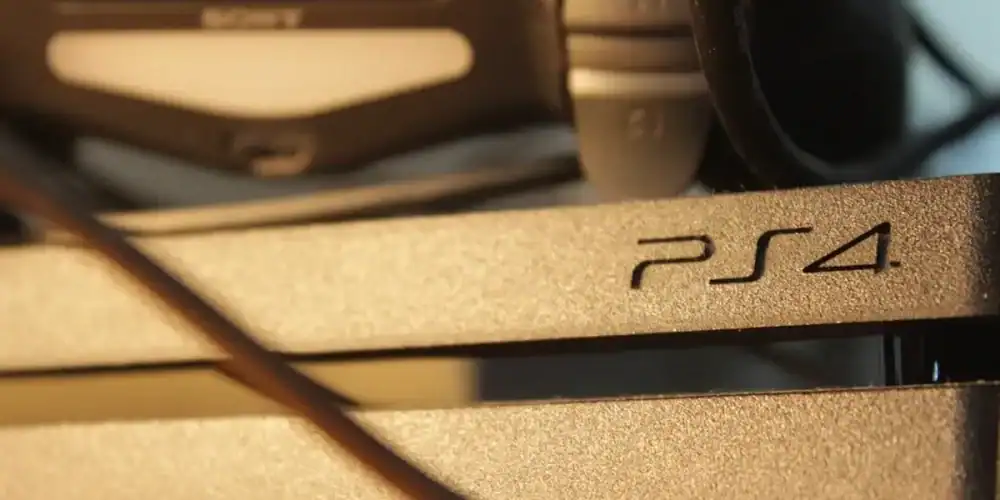 Close-up of a PS4 console with cables in the foreground