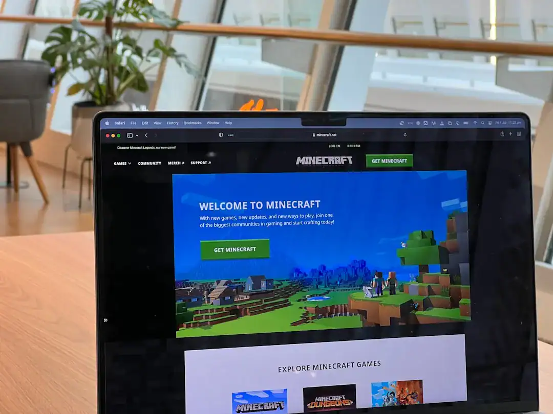 Laptop outside a bright workspace showing the Minecraft homepage
