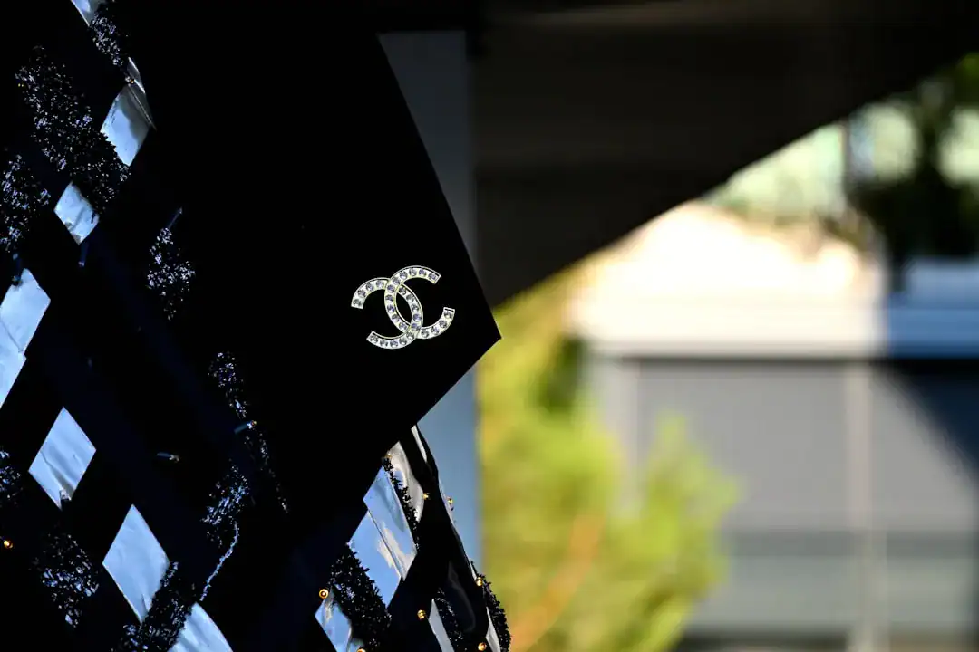 Close-up of a Chanel logo pin on a black sequined jacket