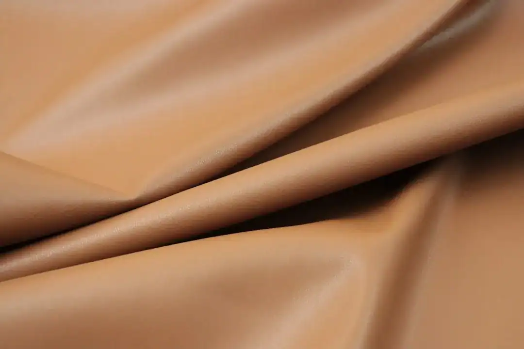 Close-up of caramel-brown leather fabric with folds