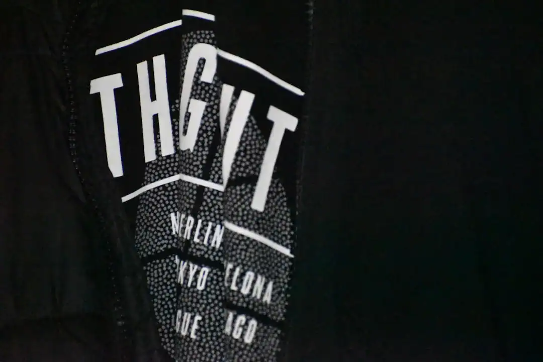 Close-up of black hoodie with bold white typography along the zipper area