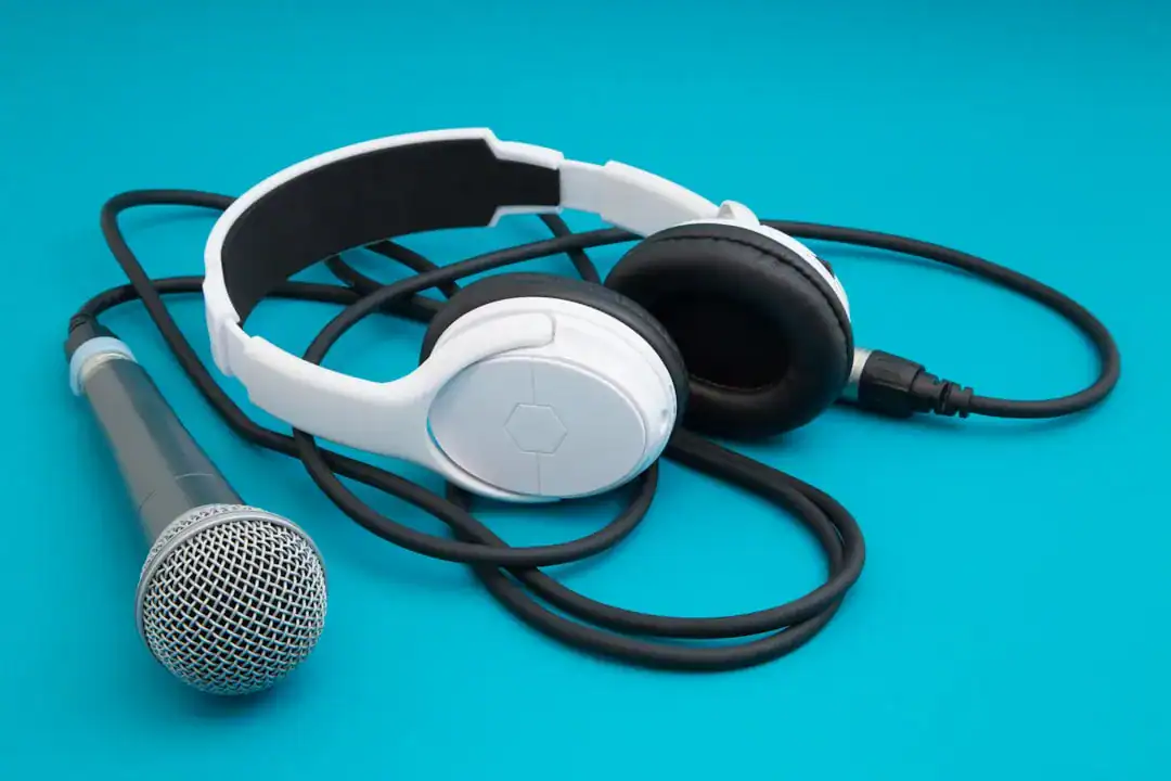 White headphones and a silver microphone on a blue background
