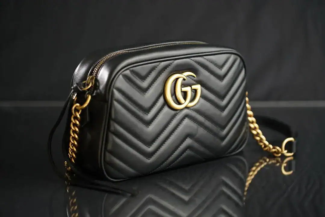 Gucci black chevron-quilted shoulder bag with gold interlocking G logo and chain strap