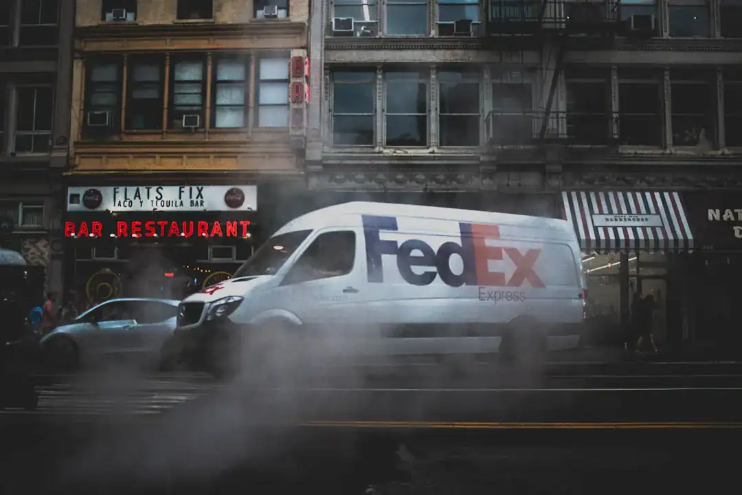 FedEx Express van driving along a foggy city street with brick storefronts
