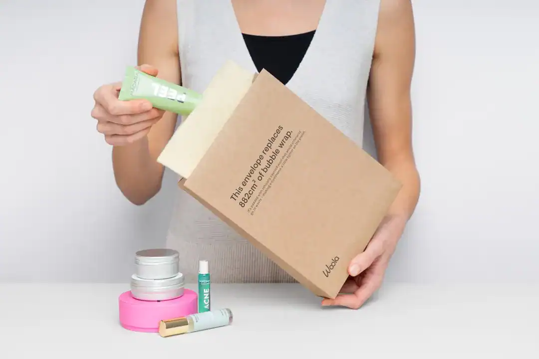 Person unboxing a skincare gift box with tubes and jars on a white table