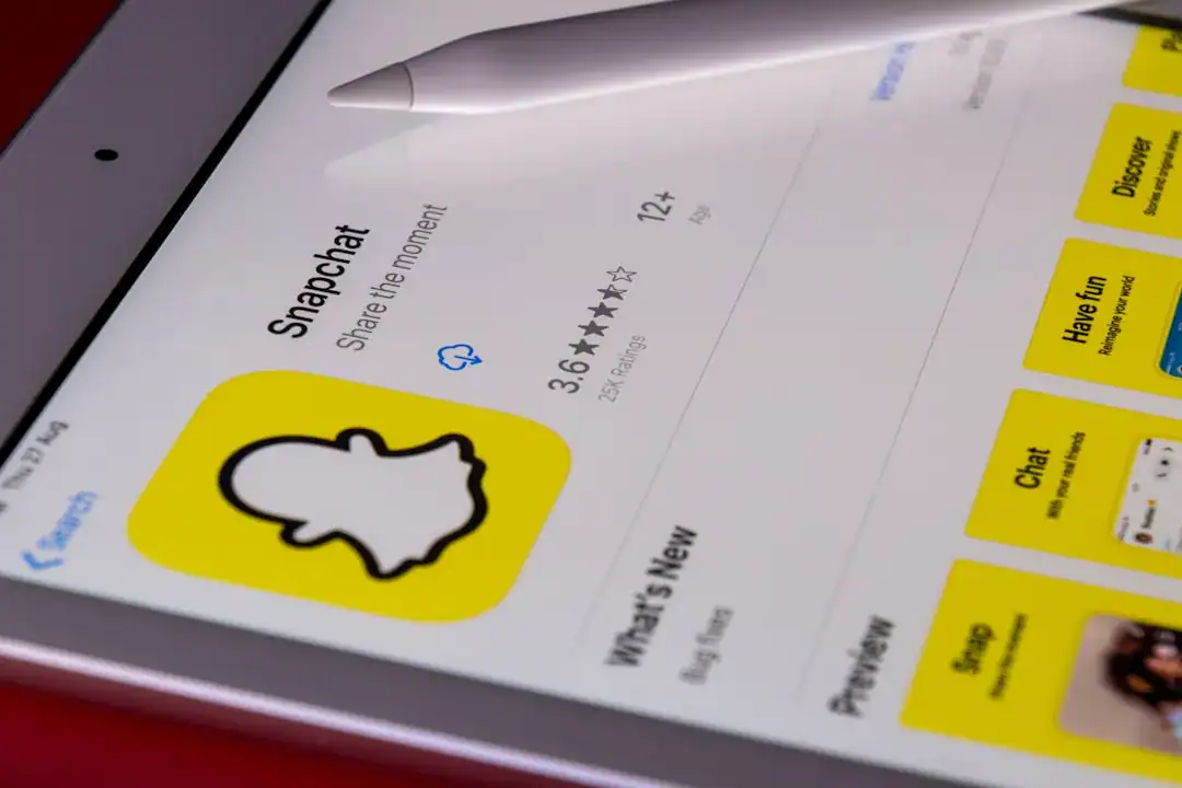 Tablet screen displaying the Snapchat app with yellow ghost icon and a white stylus.