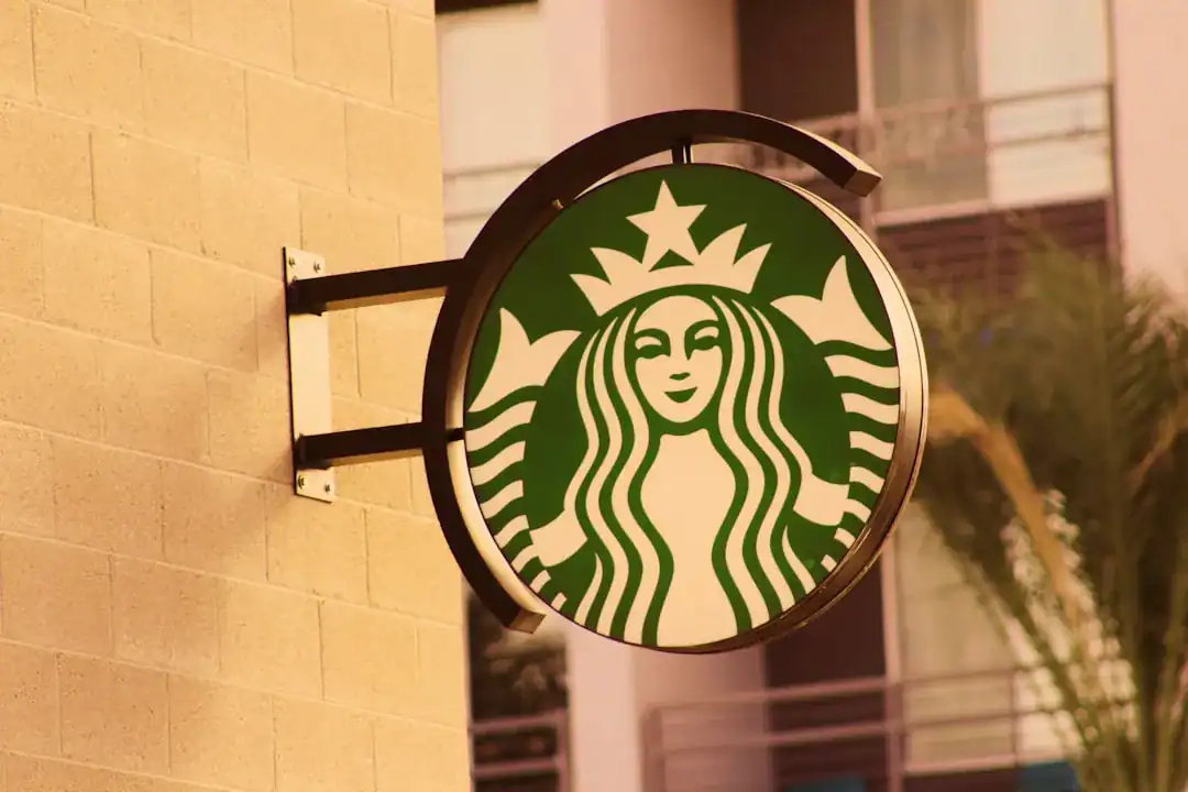 Circular Starbucks sign mounted on beige brick wall exterior