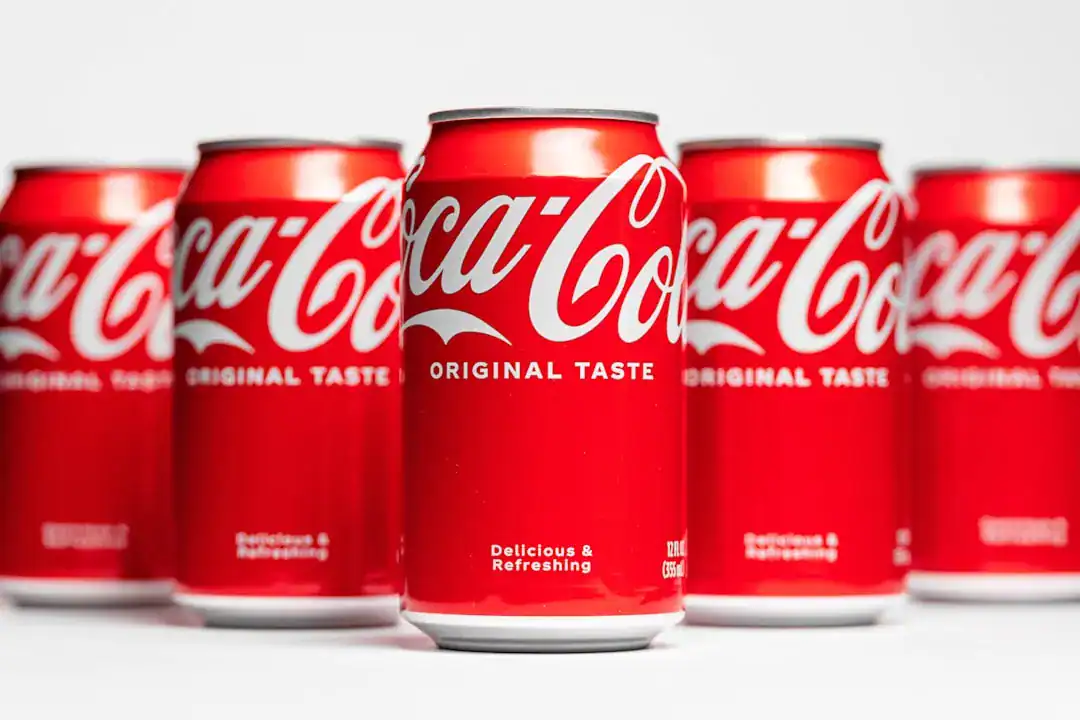 Row of Coca-Cola cans with center can in focus and others blurred