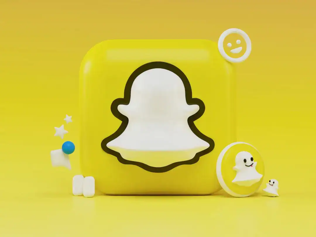 Bright yellow backdrop with a Snapchat ghost cube and round ghost stickers