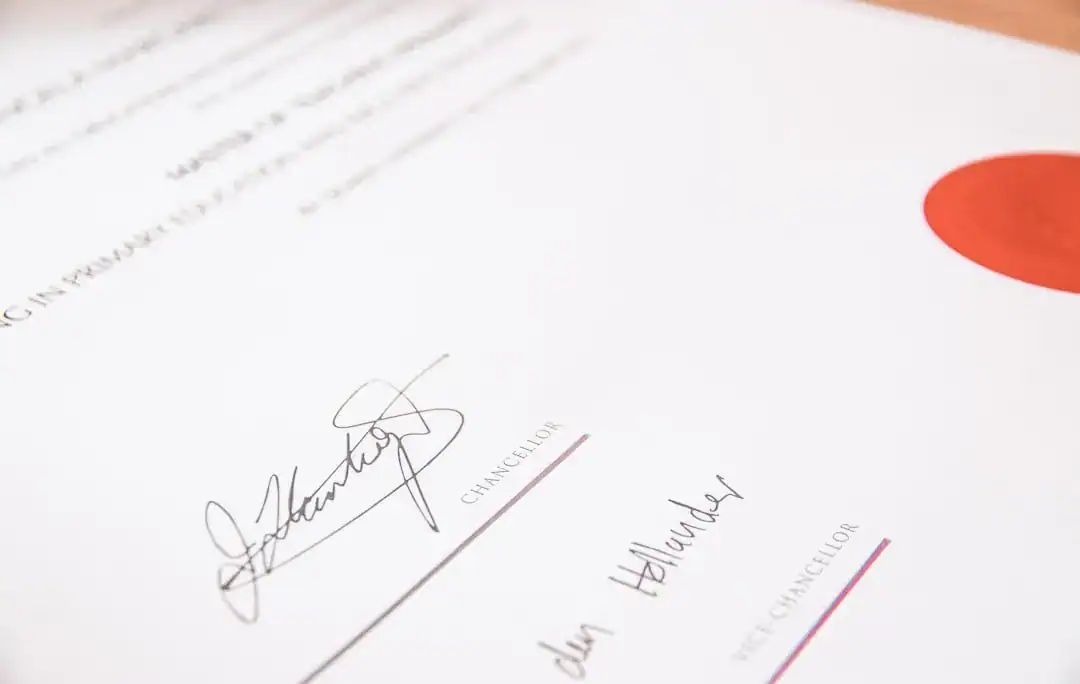 Close-up of a signed official document featuring signatures and a red seal.