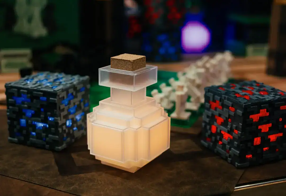 Frosted glass perfume bottle with cork stopper on a wooden table, beside voxel-pattern blocks.