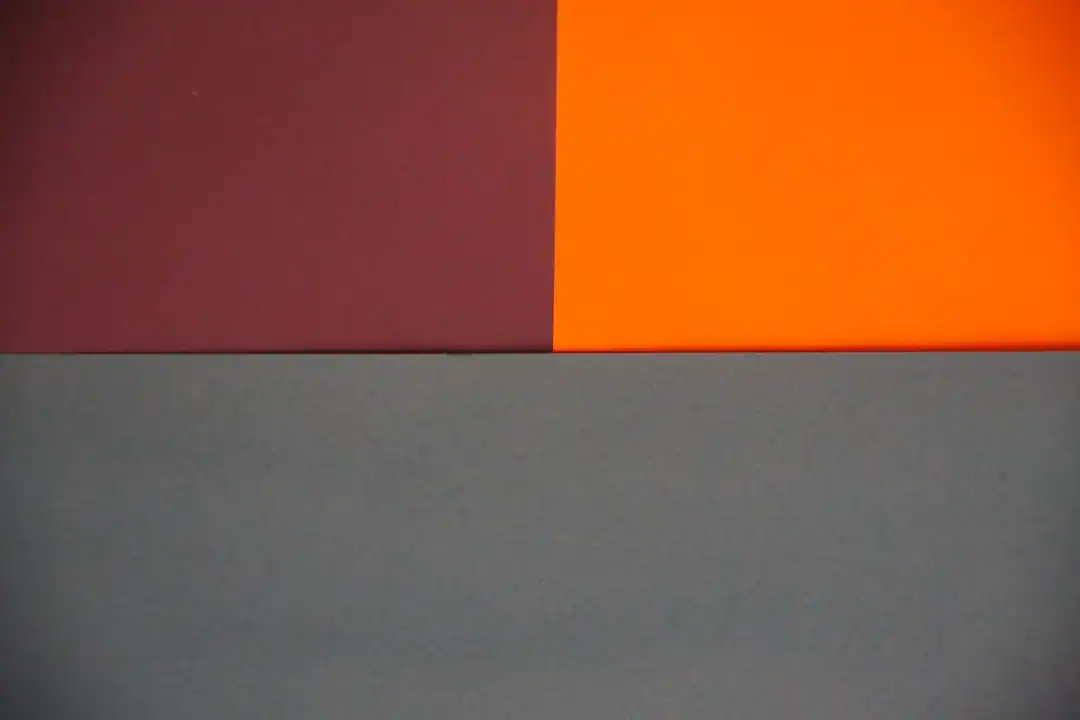 Abstract color-block image with burgundy, orange, and gray-blue panels
