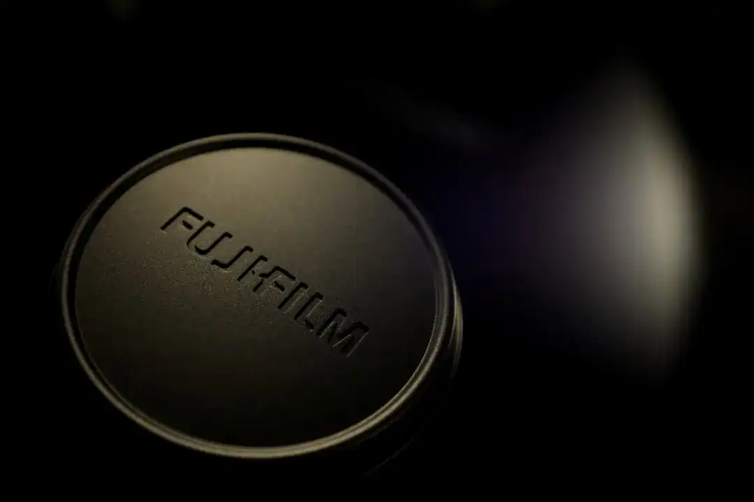 Close-up of a Fujifilm camera lens cap in dim lighting