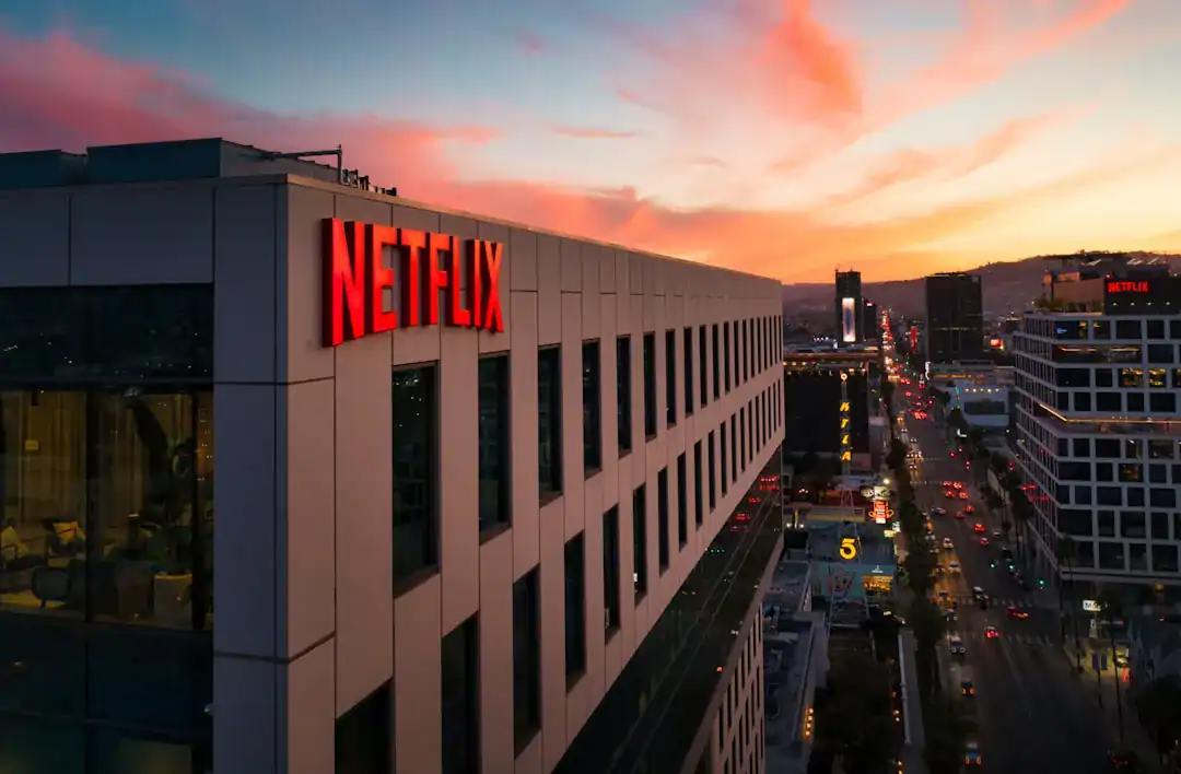 Netflix building exterior with red sign overlooking city at sunset