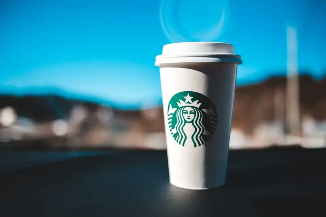 Starbucks takeout coffee cup with lid on a dark surface outdoors