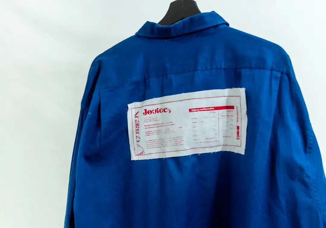 Blue work jacket with back label patch Blue back view of a jacket with a red and white label patch