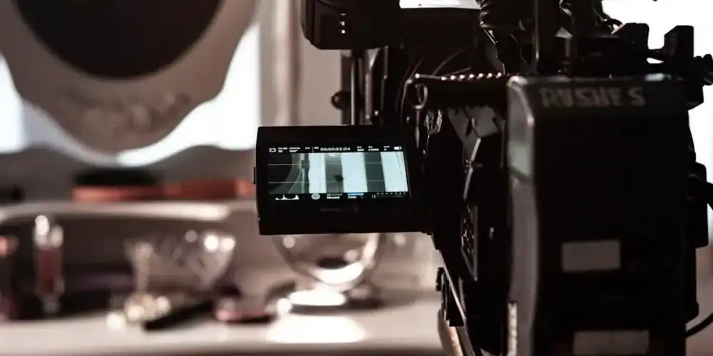 Close-up of a professional film camera on a rig in a studio with a small LCD monitor