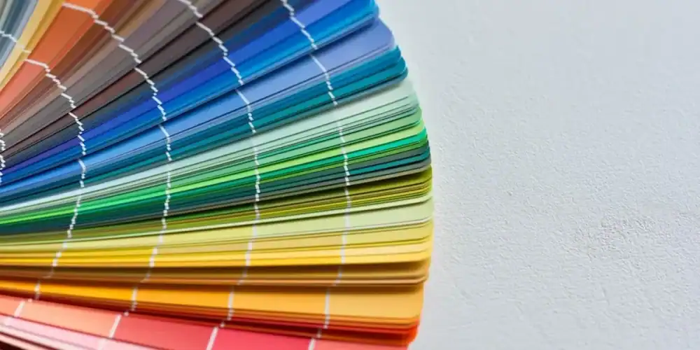 Curved rainbow color swatch fan on a light textured background.