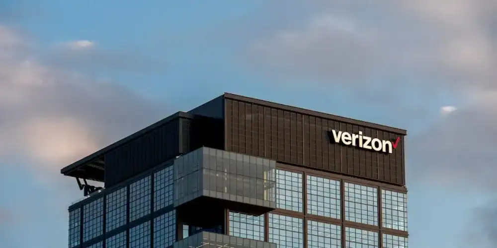 Verizon glass-clad office tower with protruding balconies under a blue sky