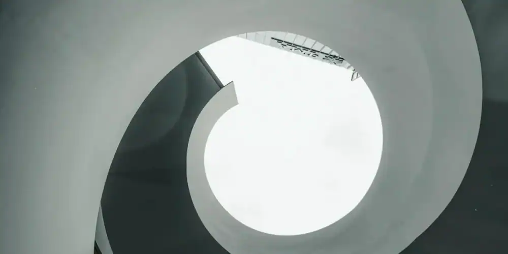 Abstract white spiral staircase viewed from below with circular opening