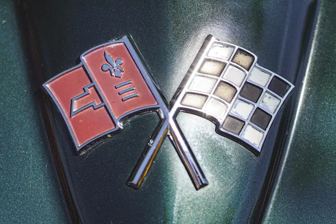 Close-up of the Corvette emblem with crossed flags on a green car hood
