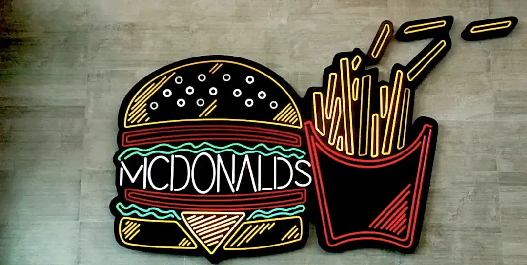 Neon sign of a hamburger and fries on a wall