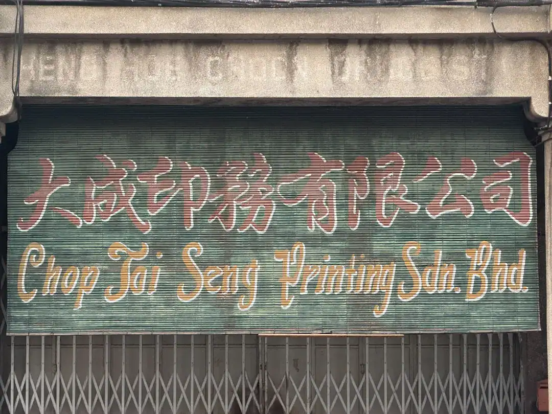 Shuttered storefront sign with Chinese characters and 'Chop Tai Seng Printing Sdn. Bhd.'