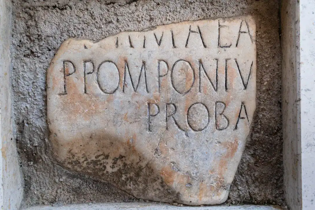 Weathered limestone slab with carved Latin inscription in a rough cement niche