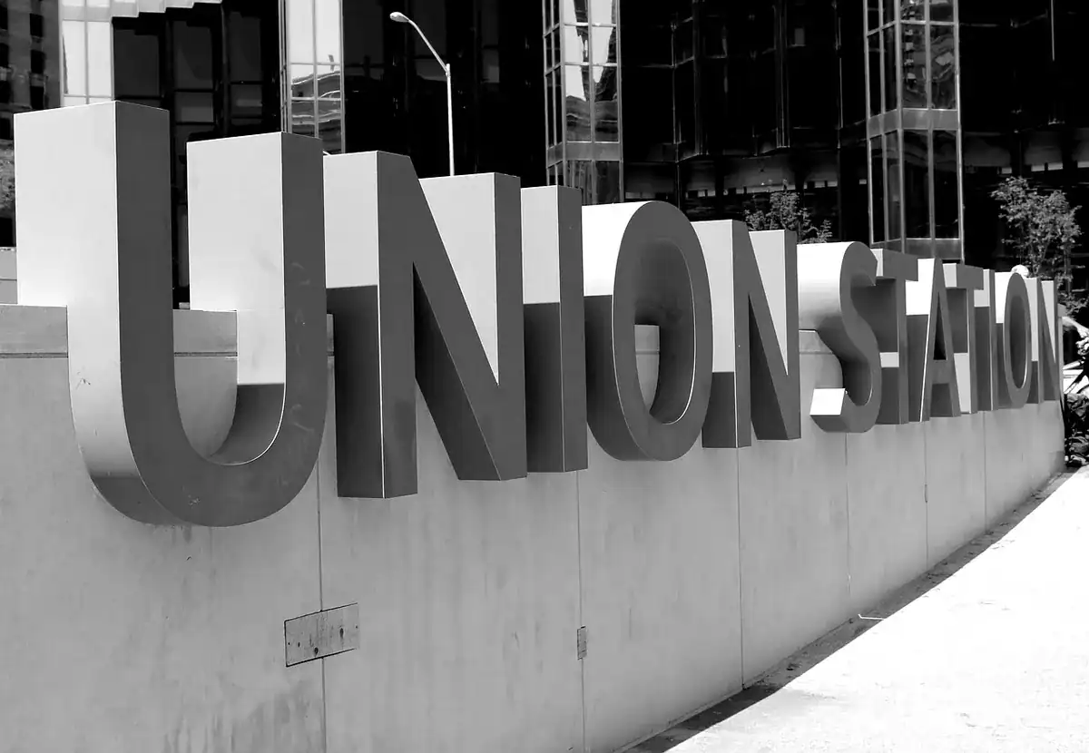 Large 3D UNION STATION letters on a concrete wall in an urban plaza.