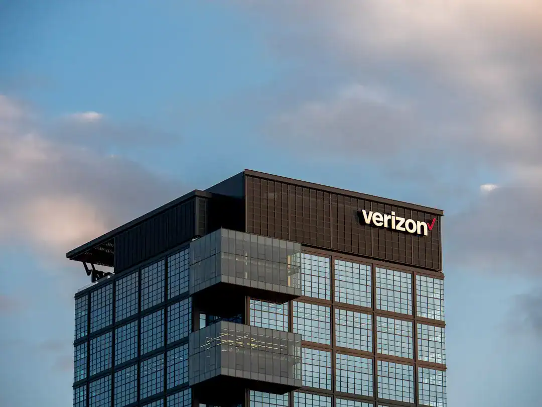 Verizon glass-clad office tower with protruding balconies under a blue sky