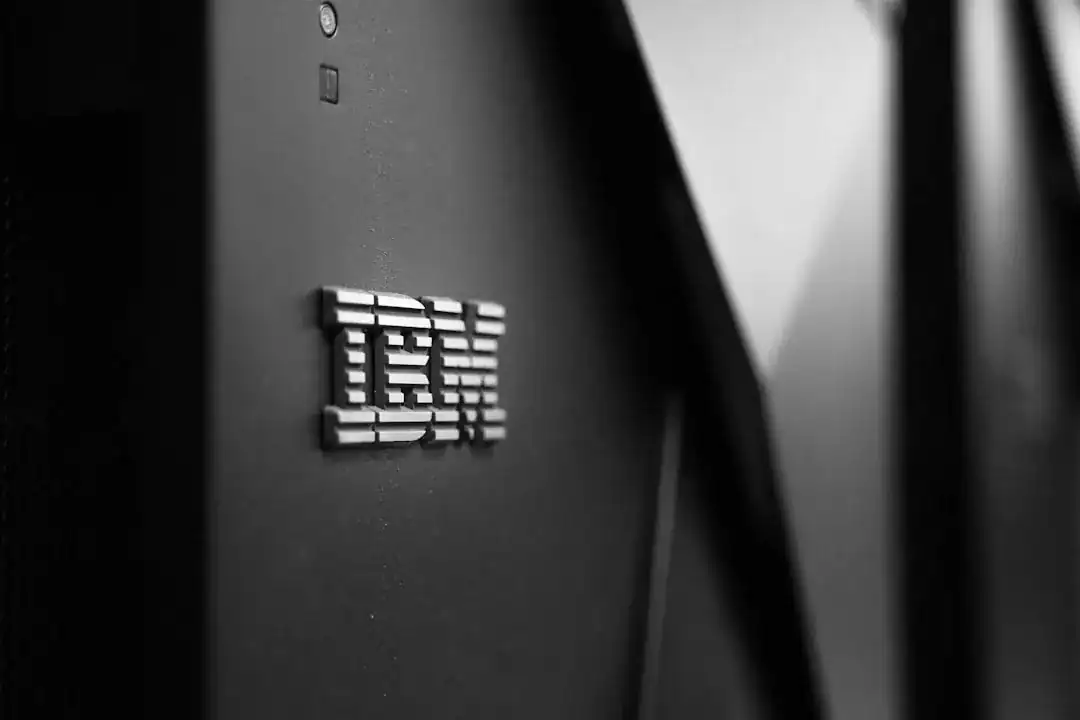 Close-up of the IBM logo on a dark server panel with blurred cables