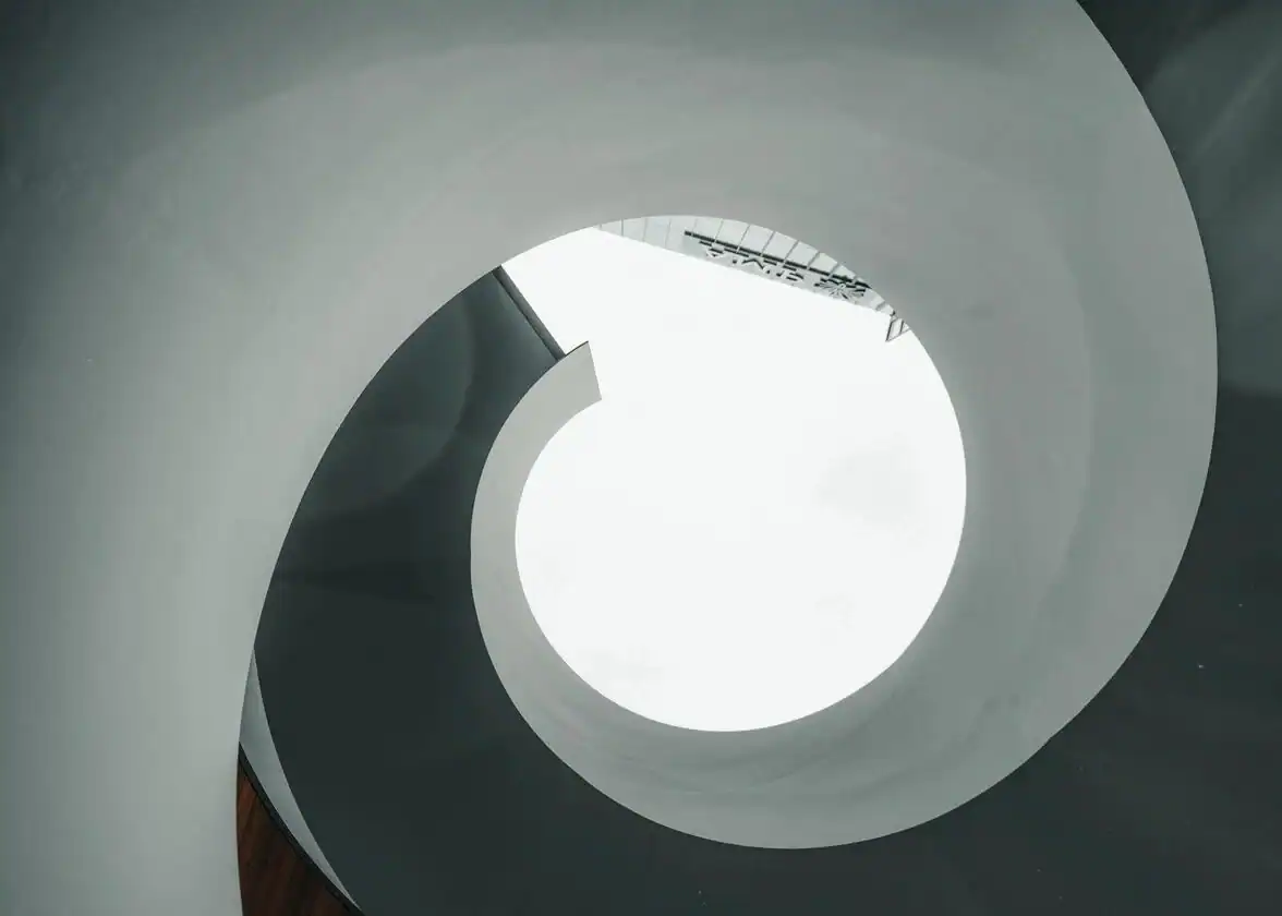 Abstract white spiral staircase viewed from below with circular opening