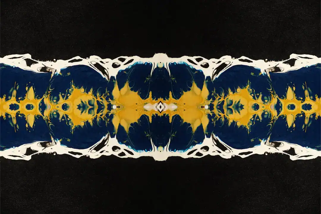 Symmetrical abstract painting with yellow and blue shapes mirrored across the center on a black background